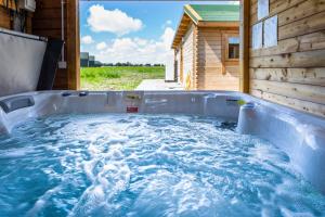 a hot tub in the backyard of a log cabin at Kings Caves Glamping in Torbeg