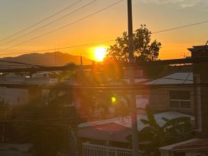 una puesta de sol sobre una ciudad con casas y edificios en DEPARTAMENTO CON TERRAZA Y VISTA para 6 personas en Chihuahua