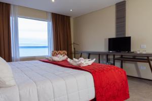 a bedroom with a bed with two lilies on it at Hotel Las Dunas in El Calafate