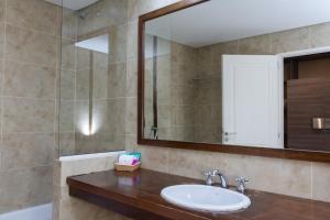 a bathroom with a sink and a mirror at Hotel Las Dunas in El Calafate +66 photos