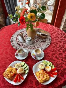 una mesa con platos de comida y tazas de café en Vāgnera parks, en Tukums