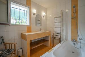 a bathroom with a tub and a sink and a shower at Le Mas de Sevrier in Sévrier