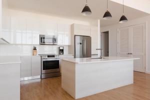 a kitchen with white cabinets and a white counter top at Sonder 17WEST in Miami Beach