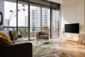 a living room with a tv and a couch and a glass table at Sonder 17WEST in Miami Beach