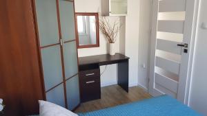 1 dormitorio con escritorio y espejo en Apartament przy Parku Centralnym, en Gdynia