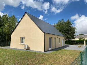 een klein huis met een zwart dak bij Maison au cœur de la nature in Cerisy-la-Forêt