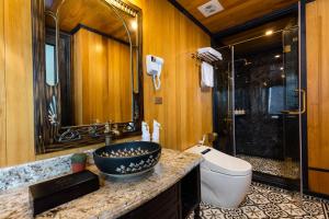 a bathroom with a sink and a toilet and a shower at La Regina Grand Cruise in Ha Long