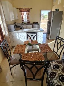 una cucina con tavolo e sedie e una cucina con frigorifero di Chad's Island Retreat a Spanish Town