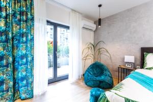 ein Schlafzimmer mit einem Bett und einem blauen Stuhl in der Unterkunft LuxuryCity Apartment with Terrace in Breslau