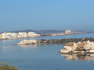 a large body of water with rocks and buildings at Gafada 2 in Trapani