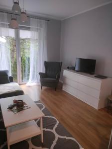 a living room with a tv and a couch and a table at Domek Mordarka in Limanowa