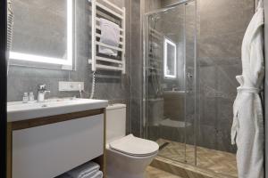 a bathroom with a toilet and a glass shower at Ribas Rooms Bila Tserkva in Bila Tserkva
