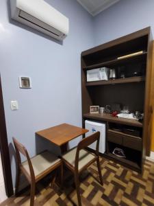 una pequeña cocina con mesa y sillas en una habitación en Suíte Lago Negro, en Gramado