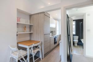 a small kitchen with a table and chairs in a room at Marylebone Gloucester Place Apartments in London