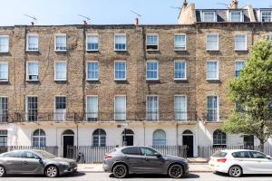 three cars parked in front of a large brick building at Marylebone Gloucester Place Apartments in London
