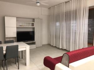 a living room with a dining table and a television at novenove in Pescara