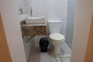 a bathroom with a white toilet and a sink at Rodeio Hotel in Rodeio Bonito +35 photos