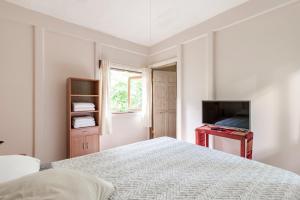 托爾圖格羅的住宿－Casa Chilamates 2.0，一间白色卧室,配有床和电视