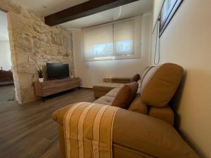 sala de estar con sofá y TV en Casa Os Chocolateiros, en Ourense