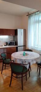 a kitchen with a table and chairs and a kitchen with a refrigerator at Apartmány Maňová 