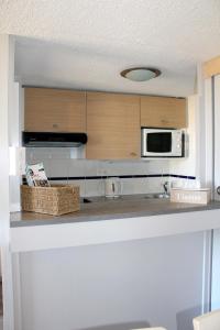 cocina con encimera y microondas en L'Aigue-Marine emplacement parfait, parking privé, en Arzon