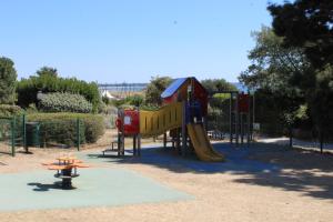 un parque infantil con tobogán en L'Aigue-Marine emplacement parfait, parking privé, en Arzon