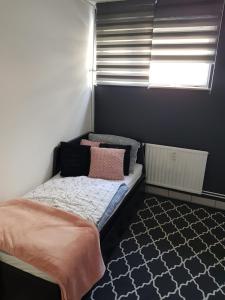 a small bedroom with a bed and a window at A place to relax in Ljubljana