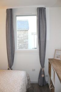 1 dormitorio con cama y ventana en L'Aigue-Marine emplacement parfait, parking privé, en Arzon