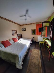 a bedroom with two beds and a desk in it at Pousada Chez Moi in Cabo Frio