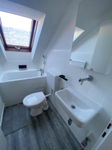 a white bathroom with a sink and a toilet at Privates neu renoviertes Zimmer in Schwaig in Schwaig bei Nürnberg
