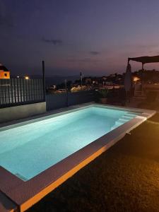 a swimming pool at night on a rooftop at Villa Fortuna in Podstrana