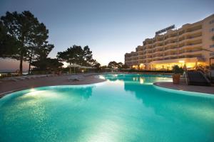 a swimming pool with a pool table in front of it at PortoBay Falesia in Albufeira