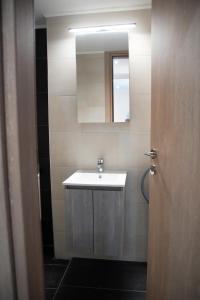 een badkamer met een wastafel en een spiegel bij Modern Apartment Downtown Athens in Athene