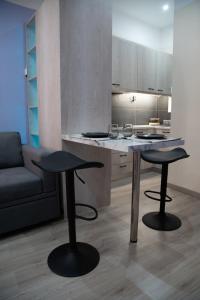 een keuken met 2 krukken en een tafel en een bank bij Modern Apartment Downtown Athens in Athene