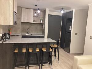 a kitchen with a counter and bar stools at Piso11 Concepcion in Concepción