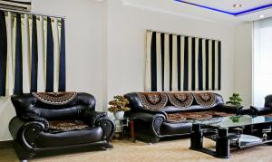 a living room with two leather chairs and a couch at Itsy By Treebo - Ashoka Grand in Varanasi