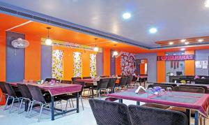 a dining room with purple tables and chairs at Itsy By Treebo - Ashoka Grand in Varanasi