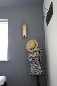 Un cappello di paglia su un vestito su un muro di Motel Hune Apartments a Blokhus