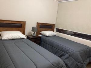 a bedroom with two beds and a window at Piso11 Concepcion in Concepción