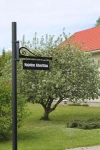 a street sign on a pole in front of a tree at Albertiina in Kurikka