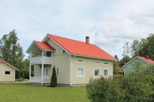 a house with a red roof on a yard at Albertiina in Kurikka