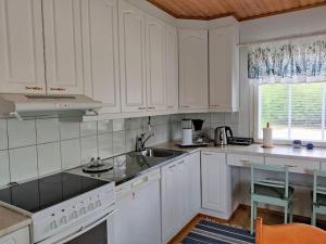 a white kitchen with white cabinets and a sink at Albertiina in Kurikka