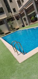 a swimming pool in front of a building at Appartement avec piscine vue sur mer dans un quartier balnéaire résidentiel animé in Nabeul
