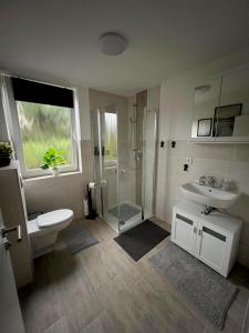 a bathroom with a toilet and a sink and a shower at 2 Exklusive Ferienwohnungen an der Nordsee in Bremerhaven