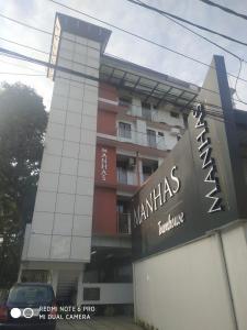 a building with a sign in front of it at Manhas Townhose in Tripunnittara