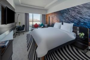 メッカにあるNovotel Makkah Thakher Cityの大型ベッドとテレビが備わるホテルルームです。