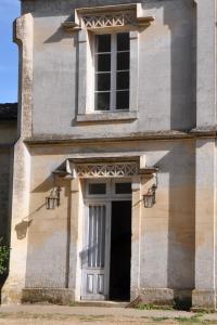an old building with a door and a window at Château du Roc in Saint-Thomas-de-Cônac