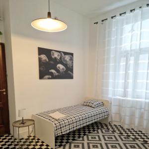 a white room with a bed and a window at Centrum ARTLwowska in Warsaw