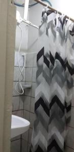 a bathroom with a shower curtain and a sink at Residência da Cláudia in Fernando de Noronha