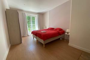 een slaapkamer met een rood bed en een raam bij Nice 230m With Garden Near Port Of Caen in Caen